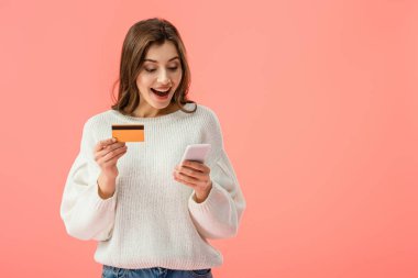 kredi kartı ve pink izole smartphone tutan sürpriz esmer kız