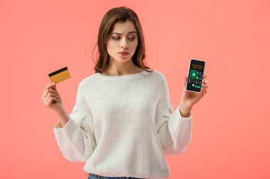 analiz pink izole ekranda pazarlama ile smartphone vasıl bakarken kredi kartı tutan çekici esmer kız 