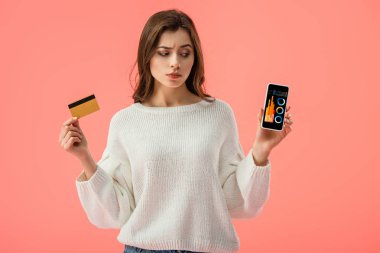 smartphone vasıl Çizelgeler ve grafikler ile pink izole ekranda bakarken kredi kartı tutan çekici esmer kız 