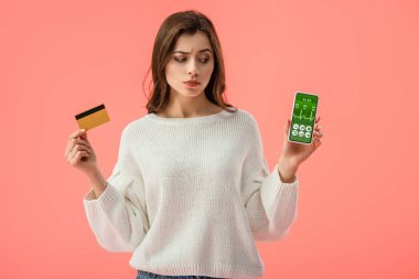 pink izole ekranda sağlık uygulaması ile smartphone vasıl bakarken kredi kartı tutan çekici esmer kız 