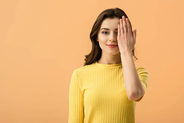 Fröhliche Junge Frau Bedeckt Auge Mit Hand Isoliert Auf Orange — Stockfoto