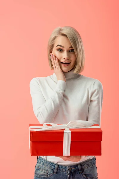 Geschokt Blonde Vrouw Met Rode Geschenkdoos Geïsoleerd Roze — Stockfoto