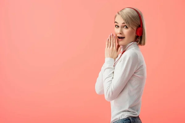 Zszokowana Kobieta Blonde Słuchania Muzyki Słuchawkach Różowym Tle — Zdjęcie stockowe