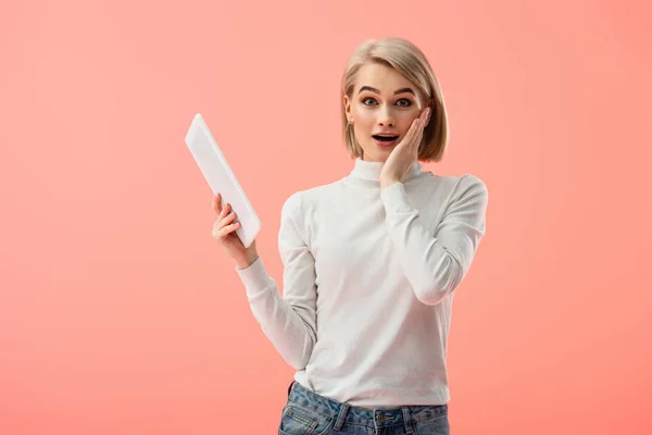 Förvånad Blond Flicka Håller Digital Tablett Isolerad Rosa — Stockfoto