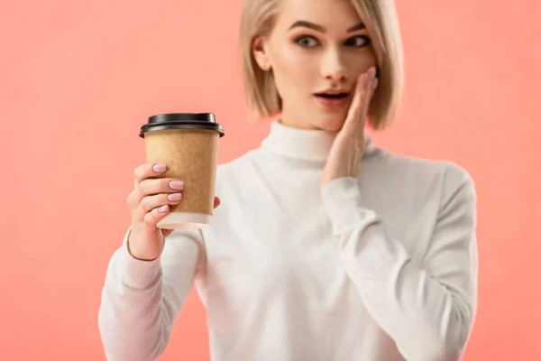 Verbaasd Blond Meisje Zoek Papier Cup Geïsoleerd Roze — Stockfoto