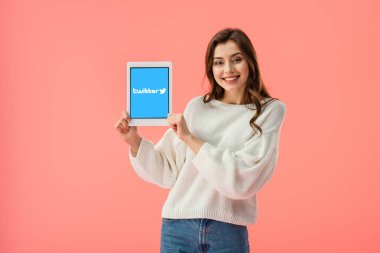 pink izole ekranda dijital tablet twitter uygulaması ile tutan mutlu genç kadın 