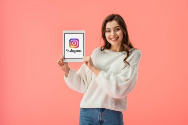 pink izole ekranda dijital tablet instagram app ile tutan mutlu genç kadın 