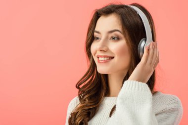 Beyaz kazak pink izole kulaklık ile müzik dinleme gülümseyen ve güzel kadın