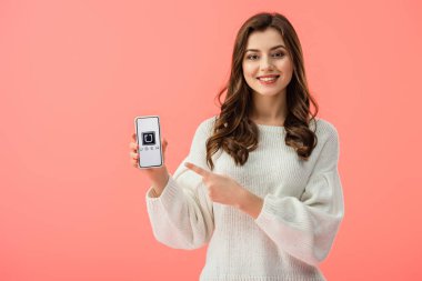 kadın beyaz kazaklı smartphone ile uber app ekranda pink izole, parmakla işaret 