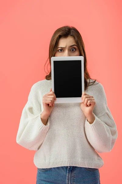 困惑的年轻女子拿着数字平板电脑与空白屏幕隔离在粉红色 — 图库照片