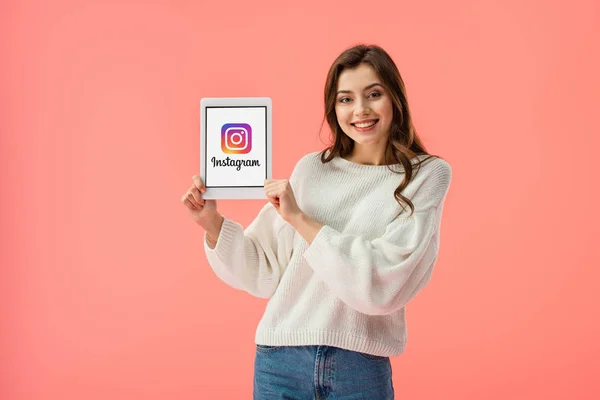 ピンクに分離された画面に Instagram アプリでデジタル タブレットを保持している幸せな若い女性 — ストック写真
