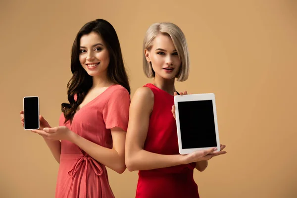 Mujeres Vestidos Rojos Sosteniendo Teléfono Inteligente Tableta Digital Con Espacio —  Fotos de Stock