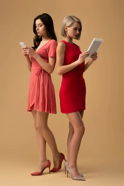 Vue Pleine Longueur Des Femmes Robes Rouges Utilisant Smartphone Tablette — Photo