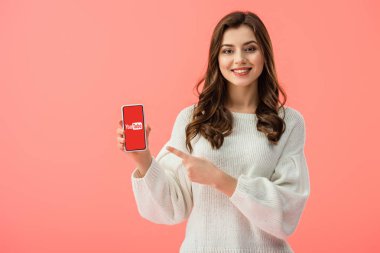 kadın beyaz kazaklı smartphone pink izole ekran üzerinde youtube uygulaması ile parmakla işaret 