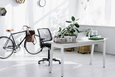 tuğla duvar, sandalye, Masa dizüstü bilgisayar ve Binalar, ağaçlar, yakın Bisiklet modelleri ofis yel değirmenleri