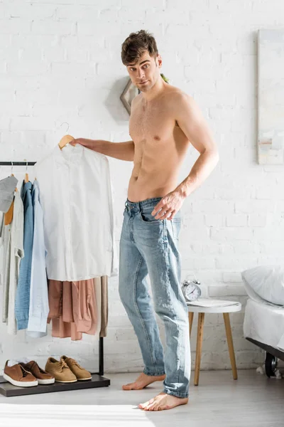 Handsome Man Bare Torso Standing Clothes Rack Holding Shirt Bedroom — Stock Photo, Image