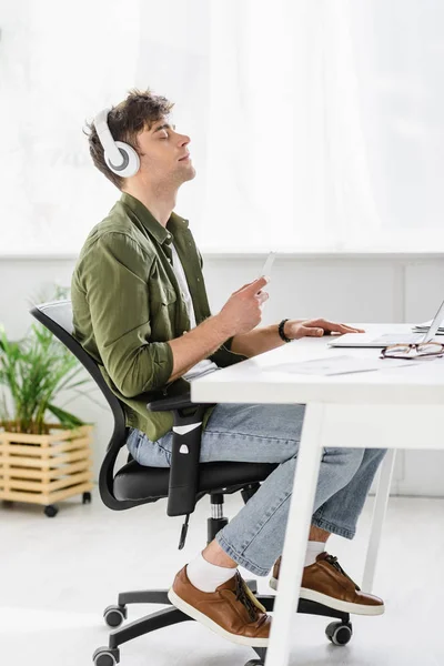 Handsome Businessman Headphones Sitting Table Laptop Holding Smartphone Listening Music — Stock Photo, Image