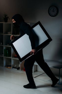 Side view of thief stealing flat-screen tv with blank screen clipart