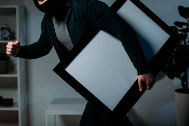 Partial view of thief stealing flat-screen tv with blank screen clipart