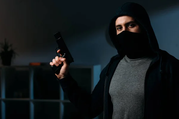 Ladrão Máscara Segurando Arma Olhando Para Câmera Quarto Escuro — Fotografia de Stock