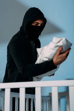 Maske ayakta yanında beşik ve holding bebek çocuk kaçıran