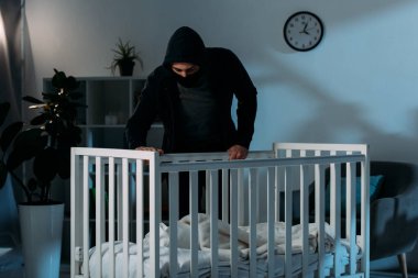 Karanlık odada ve beşik içinde seyir siyah giysili adam kaçıran