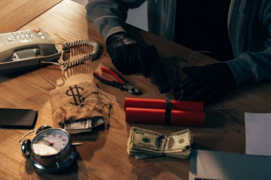 Suçlunun silahı, dinamit ve Doları banknot ile siyah eldiven kırpılmış görünümü