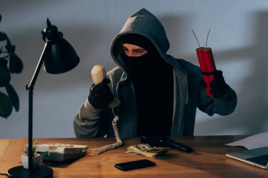 Oturma odasında ve cep telefonu tutan dinamit maskeyle kızgın terörist