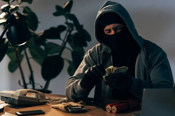 マスクと手袋の部屋でドル紙幣を数えるテロリスト — ストック写真