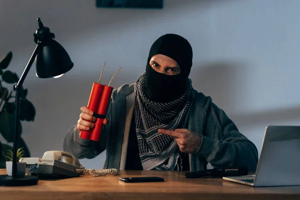 Terrorista Furioso Máscara Sentado Mesa Apontando Com Dedo Para Dinamite — Fotografia de Stock