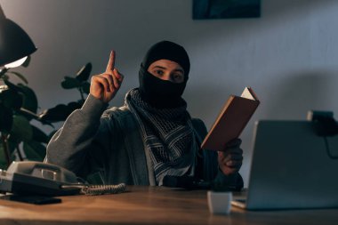Kitap okuma ve parmak ile işaret maskesi terörist