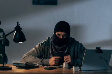 Masada silahlı saldırgan terörist oturma ve kameraya bakıyor