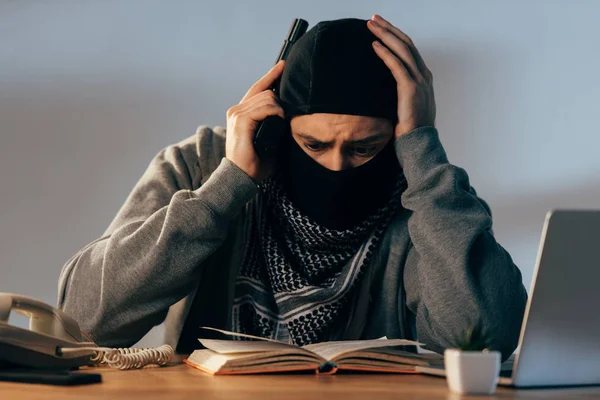 Terrorista Preoccupato Maschera Toccare Testa Durante Lettura Del Libro — Foto Stock