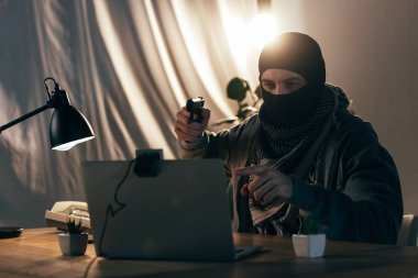 Parmak ile işaret ve silah dizüstü bilgisayar ekranında hedef maskesi ceza