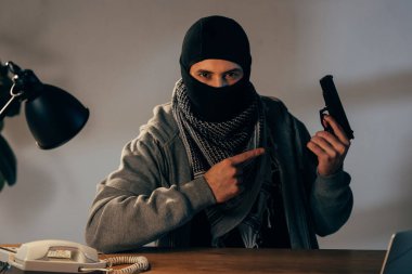 Terörist silah, parmakla işaret eden siyah maske