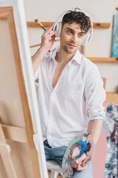 Selective Focus Handsome Artist Headphones Listening Music While Sitting Easel — Stock Photo, Image