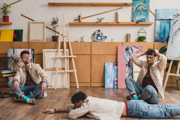 multiple exposure of artist in lying and seating poses in painting studio