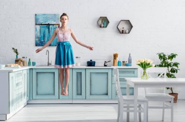 güzel yalınayak kız mutfakta havada levitating önlük