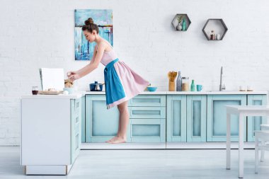 yalınayak kadın mutfakta yemek yaparken havada levitating