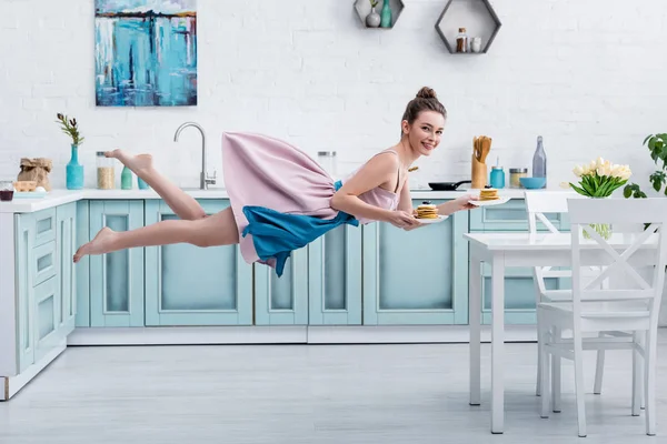 Young Smiling Barefoot Woman Levitating Air While Serving Tasty Pancakes — Stock Photo, Image