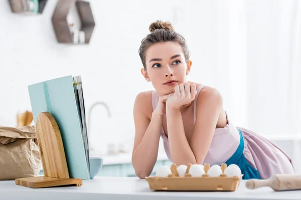 Chica Atractiva Soñadora Cerca Libro Cocina Huevos Mirando Hacia Otro — Foto de Stock