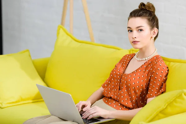 Elegáns Fiatal Sárga Kanapén Nappaliban Használ Laptop Látszó Fényképezőgép — Stock Fotó