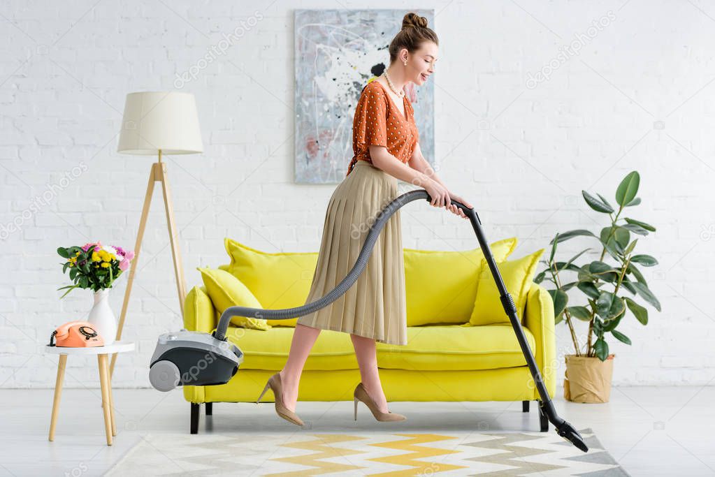 side view of elegant young woman levitating in air while vacuuming carpet