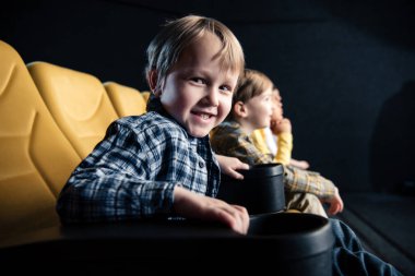 sevimli çocuk sinema arkadaşlarıyla otururken kameraya bakıyor