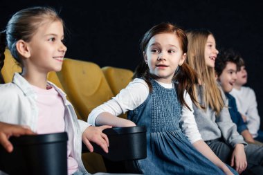 sinema oturan ve birlikte film izlerken mutlu çok kültürlü arkadaşlar