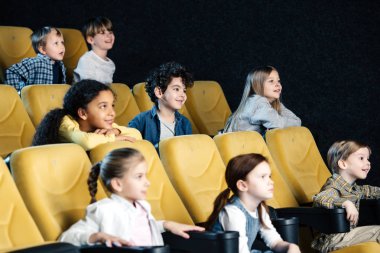 çok kültürlü arkadaşlar birlikte sinema film izlerken gülümsüyor