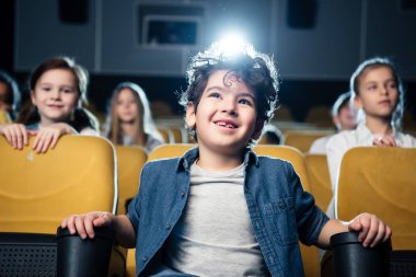 çok kültürlü arkadaşlar birlikte sinemada film seyrederken karışık yarış çocuk gülümseyen