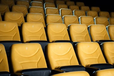 rows of comfortable orange empty seats in cinema hall clipart