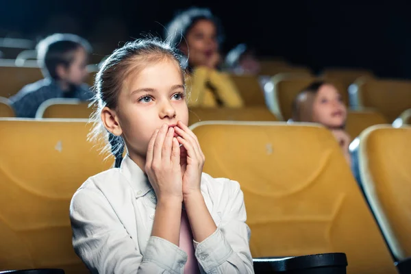 可爱的担心孩子看电影在电影院与多元文化的朋友 — 图库照片