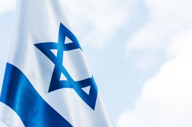 national flag of israel with blue star of david against sky with clouds   clipart